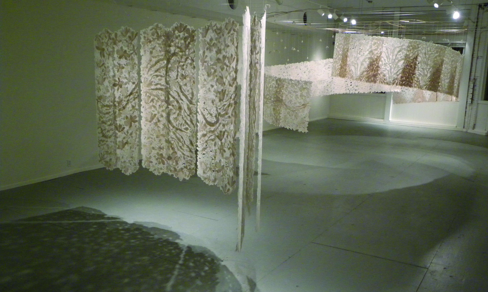 two large handmade paper installations suspended from the ceiling